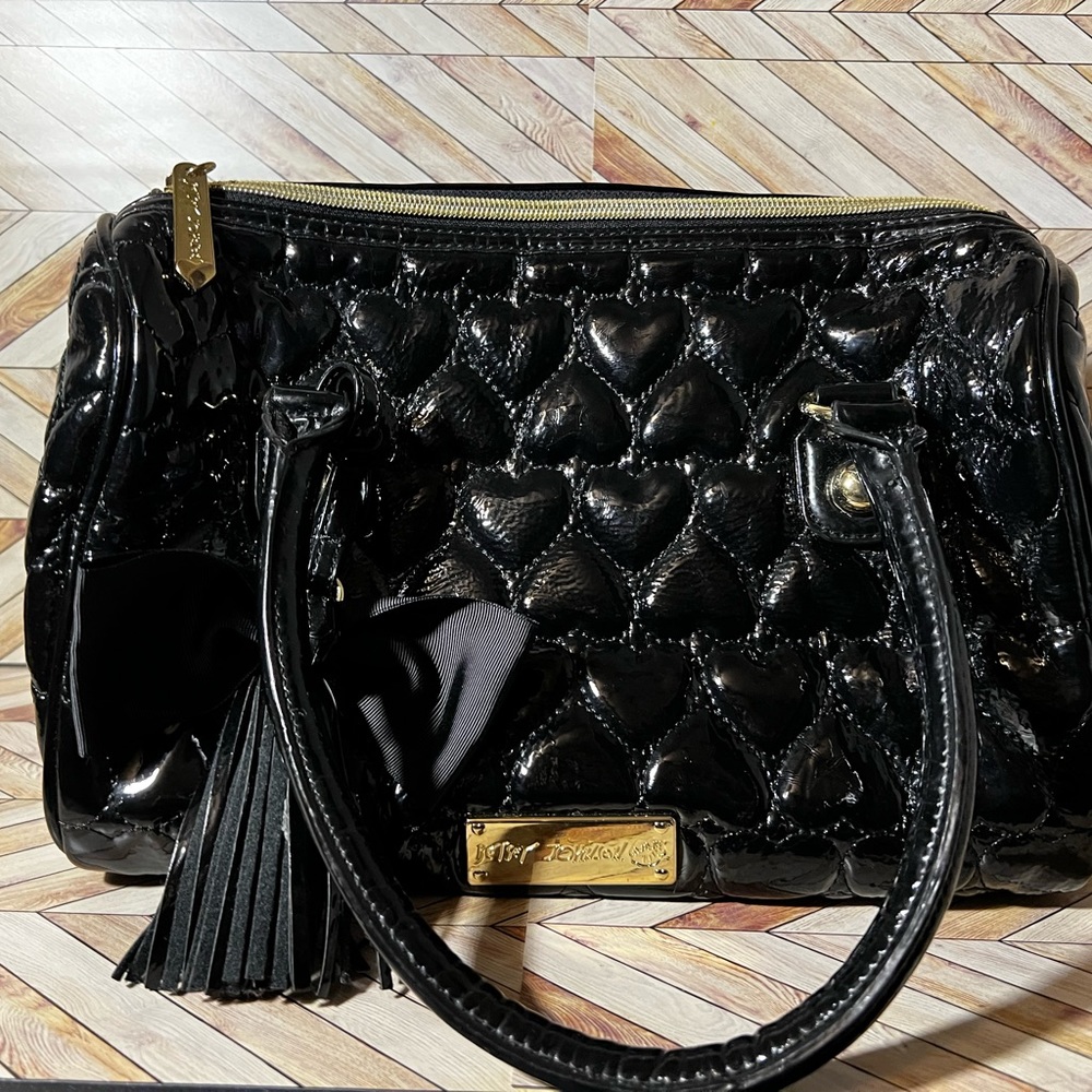 Betsy Johnson black patent leather look duffle purse with embossed hearts.
